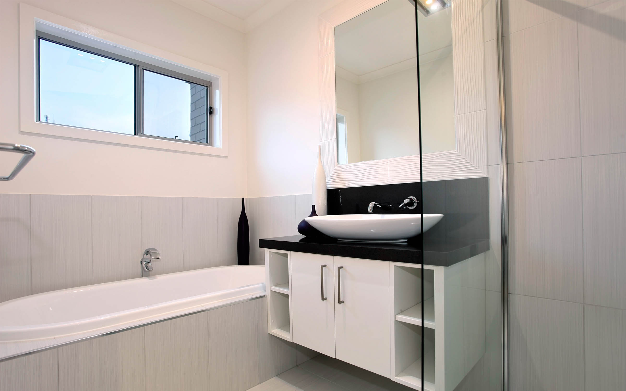 Class 1 to 10 residential bathroom with bathtub and kitchen vanity.