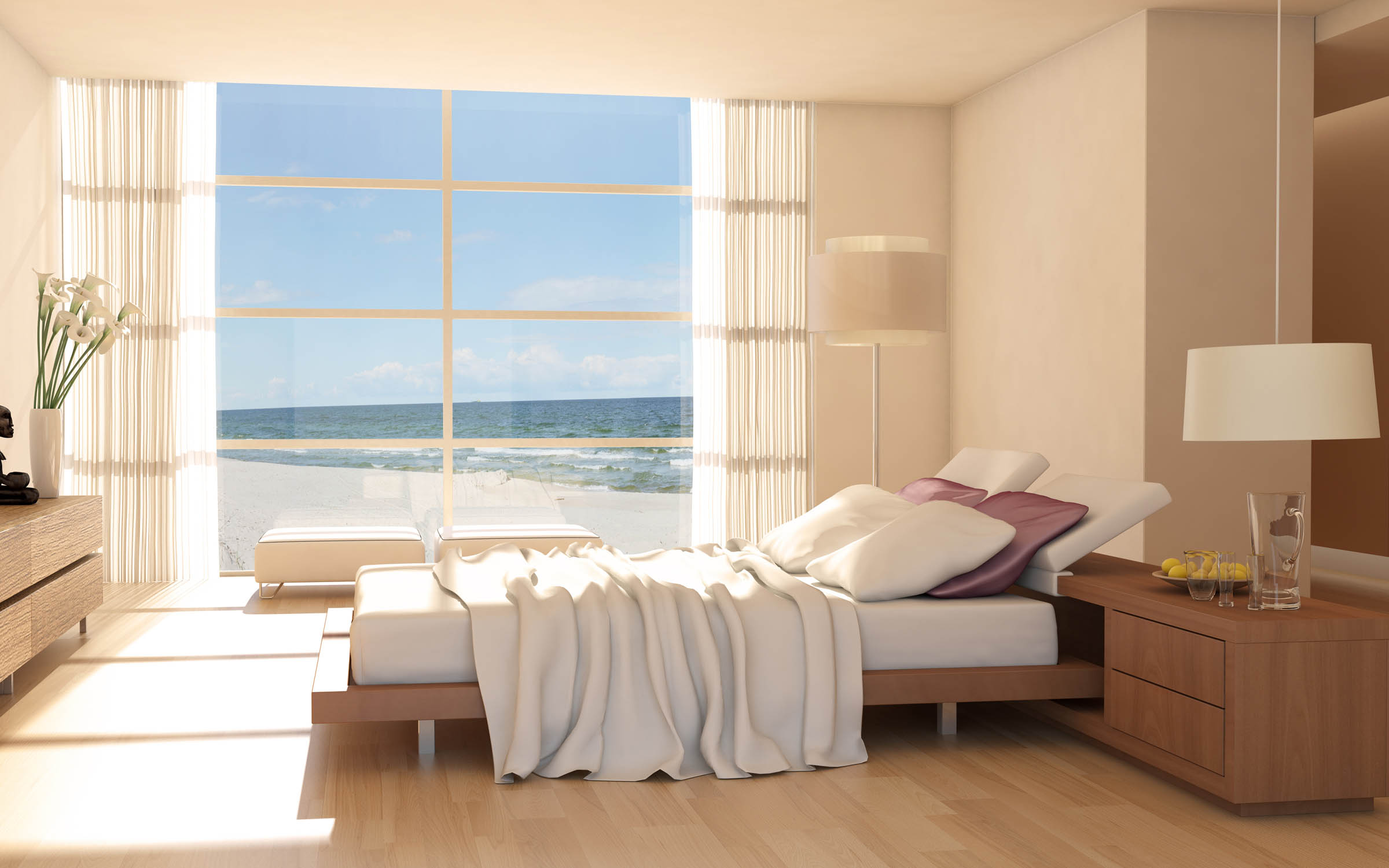 Bedroom in coastal residential area with wooden floors, and floor to ceiling windows with views of the beach.