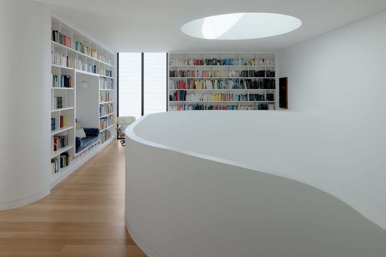 upstairs bookcases with round skylight and staircase bannister
